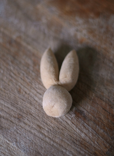 Using a sharp knife or the edge of a scraper, divide the ears by cutting down the middle of the dough.